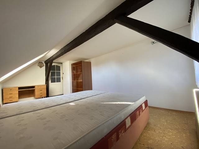 Ložnice v podkroví orientovaná na severovýchod. Střešní okno je opatřeno roletou se 100% nepropustností světla.
